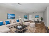 Open-concept living room featuring a modern sectional sofa, decorative rug, and adjacent dining area with bright natural light at 635 Pine Ridge Pl, Raleigh, NC 27609