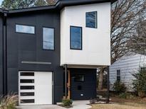 Modern two-story home with black and white exterior, attached garage, and landscaping at 707 Colleton Rd, Raleigh, NC 27610