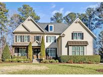 Two-story house with stone and shingle accents, landscaping, and a welcoming front porch at 7112 Hasentree Way, Wake Forest, NC 27587