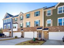 Charming townhomes with colorful facades, brick accents, and attached garages create curb appeal at 104 Ridgeline Ct, Durham, NC 27703