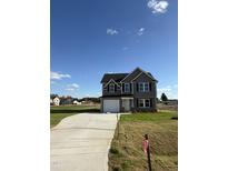Two-story house with gray siding, a driveway, and a landscaped yard at 16 Shiloh Dr, Lillington, NC 27546