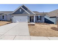 Charming single-story home with a light gray exterior, two-car garage, and well-manicured front yard at 1816 Angelonia Way, Fuquay Varina, NC 27526