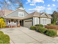 Charming home featuring a two-car garage, well-manicured landscaping, and inviting front porch with seating at 241 Serenity Hill Cir, Chapel Hill, NC 27516