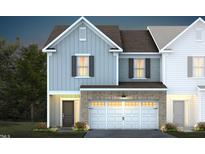 Two-story townhome with light blue and brown siding, white garage door, and landscaping at 291 Broomside Ave, Raleigh, NC 27603