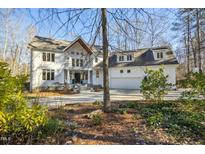 Beautiful two-story home with white exterior and ample parking in the driveway at 811 Oxbow Crossing Rd, Chapel Hill, NC 27516