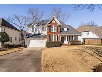 Two story brick home with attached garage and manicured lawn at 105 Wohler Ct, Cary, NC 27513