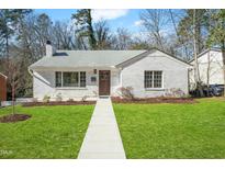 Charming white brick ranch home with landscaped lawn and walkway at 1308 Vickers Ave, Durham, NC 27707