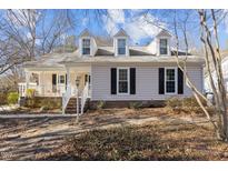 Charming single-Gathering home featuring dormer windows and a cozy front porch with white railings at 1536 Maybrook Drive Dr, Raleigh, NC 27610