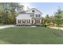 Two-story house with white siding, stone accents, and a landscaped lawn at 271 Magnolia Acres Ln, Fuquay Varina, NC 27526