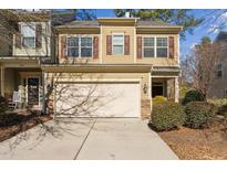 Tan two-story townhome with a double-car garage and landscaping at 320 Westgrove Ct, Durham, NC 27703