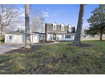 White two-story house with a gray roof, two-car garage, and a landscaped lawn at 5500 Daywood Ct, Raleigh, NC 27609