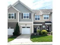 Charming townhome with a well-manicured lawn and attached garage, showcasing appealing curb appeal at 7205 Ladbrooke St, Raleigh, NC 27617