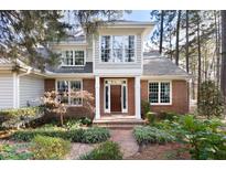 Brick two-story home with a charming front porch and landscaped yard at 76527 Rice, Chapel Hill, NC 27517