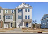 Two-story townhome with white and green siding, two-car garage, and a landscaped yard at 1040 Myers Point Dr, Morrisville, NC 27560