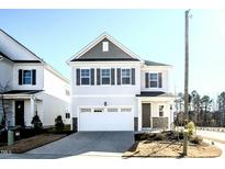 Two-story home with gray and white siding, white garage door, and landscaping at 1183 Pate Farm Ln, Durham, NC 27703