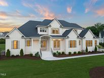 Stunning two-story home with white siding, black roof, and a beautifully landscaped front yard at 1608 Legacy Ridge Ln, Wake Forest, NC 27587