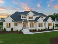 A beautiful two-story home with white siding, dark roof, manicured lawn, and inviting front entrance at 1608 Legacy Ridge Ln, Wake Forest, NC 27587