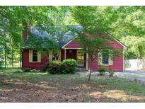 Charming single-story home with red siding, complemented by lush greenery and mature trees at 211 Dwelling Pl, Knightdale, NC 27545