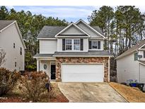 Two-story house with gray siding, stone accents, and a two-car garage at 2730 Erinridge Rd, Raleigh, NC 27610