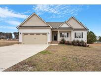 Two-story house with beige siding, a two-car garage, and landscaping at 45 Green Pine Cir, Princeton, NC 27569