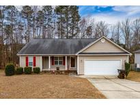 Tan house with red shutters, attached garage, and a small front yard at 521 Tucks Ct, Sanford, NC 27330