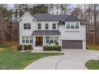 Two story white brick home with gray roof and a 3-car garage at 8101 Fergus Ct, Wake Forest, NC 27587