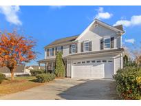 Charming two-story home with a two car garage, beautiful landscaping, and a well-manicured lawn at 102 Redstone Dr, Gibsonville, NC 27249