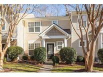 Tan siding two-story townhome with landscaping and walkway at 11215 Lofty Heights Pl, Raleigh, NC 27614