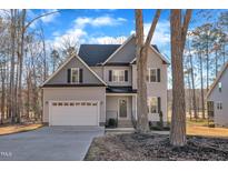 Two-story house with gray siding, white garage door, and landscaping at 167 Black Cloud Dr, Louisburg, NC 27549