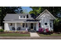 Charming single-Gathering home with a inviting front porch, beautiful landscaping and American flag at 223 N Main St, Wendell, NC 27591