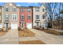 Three-unit townhome complex with attached garages and landscaping at 386 Cotton Brook Dr, Fuquay Varina, NC 27526