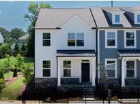Charming two-story townhome with white siding, stone accents, and a well-manicured front yard at 500 Traditions Grande Blvd # 22, Wake Forest, NC 27587