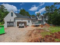 Beautiful newly built home with gray painted brick, dark roof, large garage and long driveway at 7013 Buckhead Dr, Raleigh, NC 27615