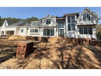 Under construction, a two-story home with black windows and brick base ready for siding at 7013 Buckhead Dr, Raleigh, NC 27615