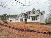 Striking new construction home with a modern design, large windows, and a charming light gray facade at 7013 Buckhead Dr, Raleigh, NC 27615