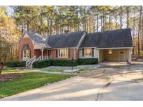 Brick ranch house with attached garage, landscaping, and driveway at 1210 Huntsman Dr, Durham, NC 27713