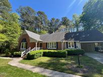 Charming brick home with well-maintained landscaping, sidewalk, and attached garage at 1210 Huntsman Dr, Durham, NC 27713