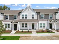 Three-unit townhome building with white and gray siding, landscaping, and parking at 124 Camel Crazies Pl # 43, Lillington, NC 27546