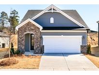 Charming home with stone accents, a two-car garage, and well-maintained landscaping at 213 Little Crk Dr, Lillington, NC 27546