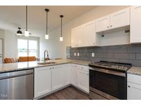 Modern kitchen with granite countertops, stainless steel appliances, and white shaker cabinets at 2206 Gathering Sq Ct # 2206, Fuquay Varina, NC 27526