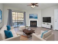Living room features fireplace, balcony access, and hardwood floors at 3804 Chimney Ridge Pl # 106, Durham, NC 27713