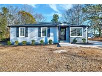 Newly renovated home with gray siding, stone accents, and landscaping at 406 Everette Ave, Clayton, NC 27520