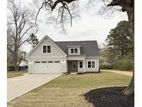 Charming home featuring a gray exterior, well-manicured lawn, and a two-car garage at 504 Tucker St, Four Oaks, NC 27524
