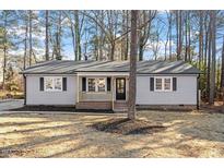 Newly renovated house with gray siding, a brick base, and a welcoming front porch at 602 N Mineral Springs Rd, Durham, NC 27703