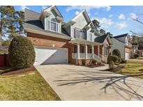 Charming two-story brick home with attached garage and well-manicured front yard and covered entryway at 8005 Sundance Cir, Durham, NC 27713