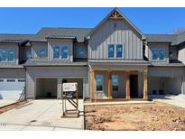 Charming townhome exterior features a covered porch, gray siding, and a two-car garage at 1031 Coldspring Circle, Durham, NC 27705