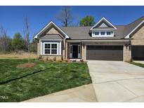Charming, single-story brick home with a well-manicured lawn and a two-car garage at 2099 Harris Farm Ct, Burlington, NC 27215