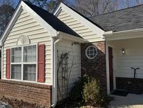House exterior featuring vinyl siding, brick accents, and a red door at 6020 Newhall Rd, Durham, NC 27713