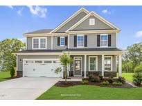 Two-story house with gray siding, white trim, and a two-car garage at 8805 Melvin St # 35, Willow Springs, NC 27592