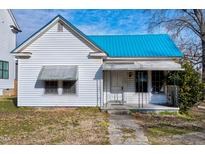 White house with teal roof, front porch, and small lawn at 110 Summit Ave, Raleigh, NC 27603